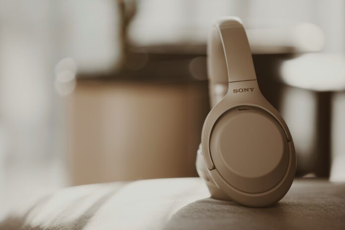 Sony over-ear wireless headphones in beige finish placed on a sunlit sofa – elegant, minimalist tech design.