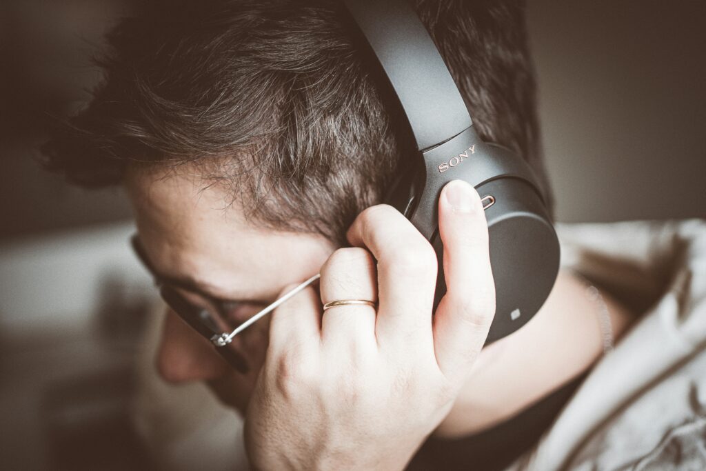 Person listening to music with Sony over-ear headphones – immersive listening experience.