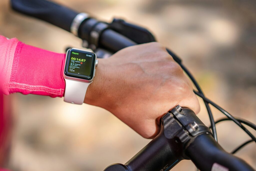 Cyclist tracking workout performance on smartwatch — GPS and activity tracking features in today’s best fitness trackers.