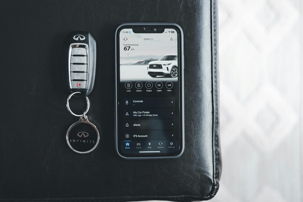 Car remote next to smartphone displaying remote control dashboard