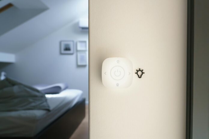 Minimalist smart home light control panel mounted on a bedroom wall, showcasing modern home automation