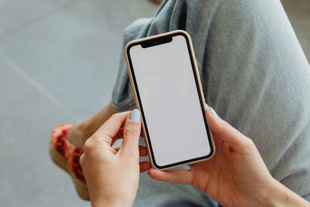 Person holding a smartphone with blank screen